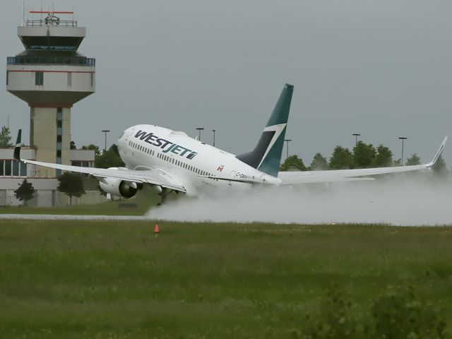 Boeing 737-700 (C-GMWJ) - Taking off on a wet and rainy Rwy 25