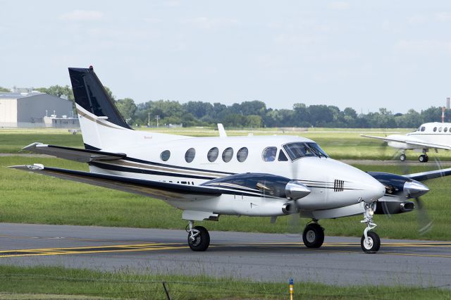 Beechcraft King Air 90 (N904TH) - Clouds often appear at inopportune times! An oil and gas company C90A taxis out will a US Army C-12 lands in the background. -August 2013