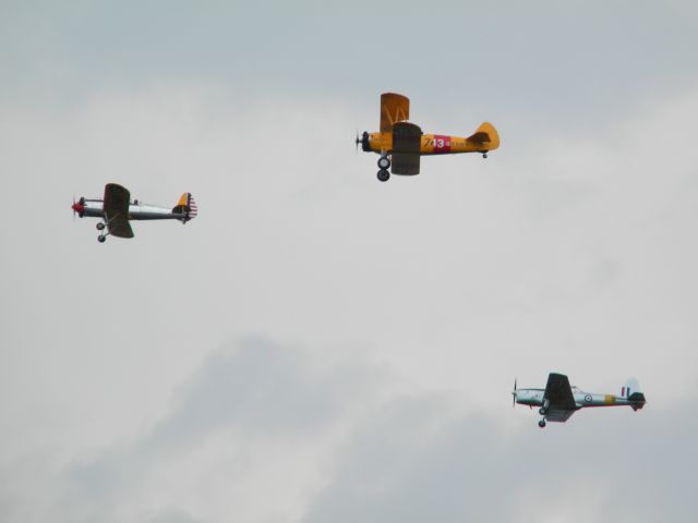 — — - A Steerman, Chipmunk, and another trainer flying in formation.WW II in Color series.