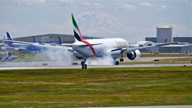 Boeing 777-200 (A6-EFN) - BOE41 makes tire smoke on landing Rwy 16R on 6/19/14. (LN:1212 / cn 42232). Mt Rainier can be seen in the distance.