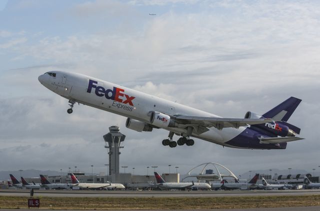 Boeing MD-11 (N631FE) - This is the iconic Los Angeles/LAX photo. Having plowed through the dust on takeoff, the theme restaurant and control tower make the picture. This MD11 is taking off from runway 25L. Memphis here we come! Photo taken looking north. 14 May 2014 07:05 PDT