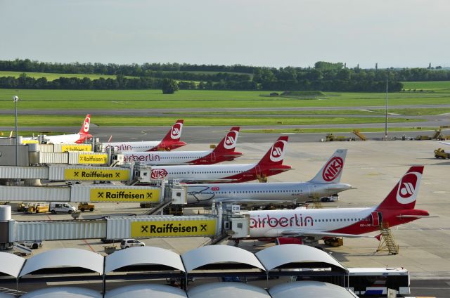 Airbus A319 (OE-LNE) - Panoramic view of Terminal 1 of Vienna International Airport at busy time, with Niki Airbus A319-112 OE-LNE in front