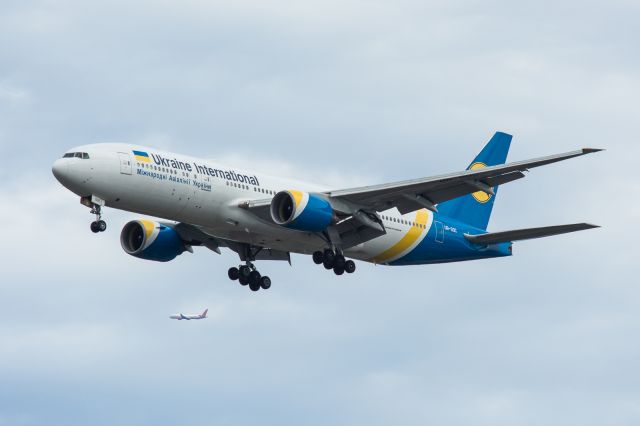 Boeing 777-200 (UR-GOC) - 31R arrival with a departure in the background.