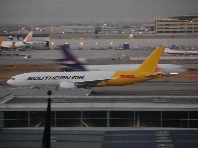 BOEING 777-200LR (N714SA) - Southern Air?DHL 777-200LRF seen in early light as a FedEx MD-11F passes behind on takeoff!