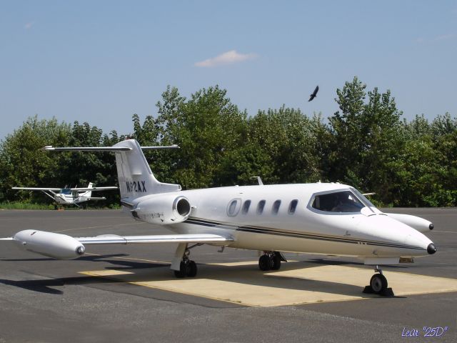 Learjet 25 (N82AX) - One of the older twin engine Lear Aircraft seen here while a hawk passes in the background in the Summer of 2005.