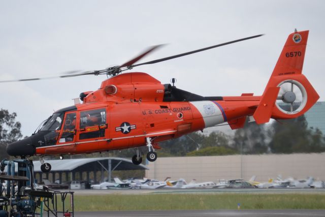 Cessna Skyhawk (N6570) - 6570 is one of the Coast Guards MH-65D Dolphin helicopters and is seen here departing the Signature Flight Support ramp. When this was snapped, the helicopter was over taxiway "Alpha" and they were departing VFR to the north (probably back to their LAX base, but unverified). Ideally, the shot wouldnt have the work truck in the lower left corner, but I didnt have much space as there were aircraft wings both to the right and left of this shot, so I only had one chance to get a mostly clean shot and luckily I did.