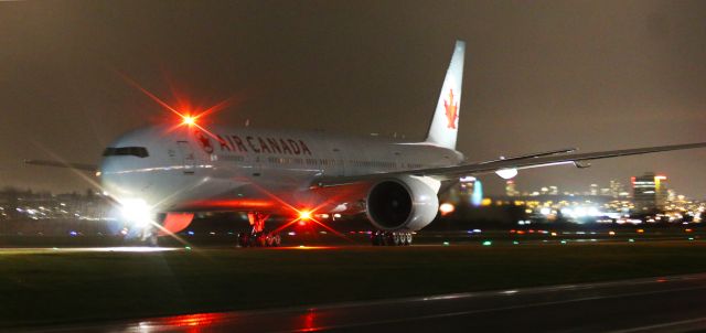 BOEING 777-300 (C-FNNU) - Air Canada Boeing 777-333(ER) C-FNNU evening arrival in the rain at YVR from YYZ with a double beacon / lens flare.