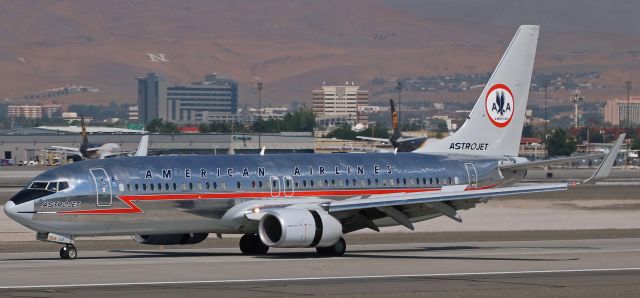 Boeing 737-800 (N905NN) - Timing its arrival perfectly yesterday morning, AALs newly painted "Astrojet" retro liverybird (N905NN, which recently replaced N951AA as the American Astrojet paintbird) reverses thrust after landing on RNOs 16L at 10:22 AM, just two minutes after the prime eclipse time (the time when maximum eclipse coverage happened) officially occurred over Reno - 10:20 AM.  Although Renoites did not get to see a total eclipse, a great majority of the sun was obscured at 10:20 AM which is why the sky over the top of the mountains in the upper right corner of this photo is quite dark.  This is the second time N905NN has visited Reno since it was reclothed into this new garb.