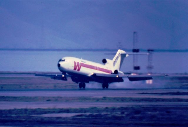 BOEING 727-200 — - KSFO Western Airlines Boeing 727 landing at SFO date apprx July 1982 - on 28LR - the old central parking garage at SFO was a great afternoon jet watching area and great for photos before the Terminal was added blocking most of this view. One could not see the whole runway view towards the left in view but you could see all approaching traffic for the 28LR runways and smoky touchdowns as this shows here as this 727 arrives from KSLC Salt Lake City. This was a color slide with my then new Celestron C-90 1000mm lens hand held. Unknown reg.