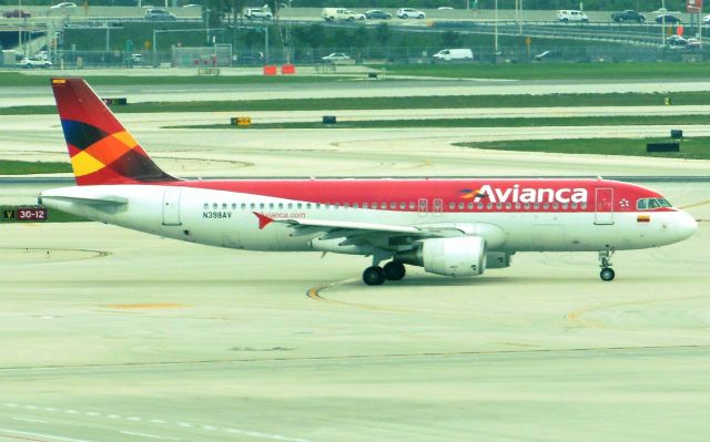 Airbus A320 (N398AV) - Avianca (AV) N398AV A320-214 [cn3988]br /Miami (MIA). Avianca flight AV31 taxis for departure to Medellin (MDE). Wearing the last of the colorful ‘orange fuselage’ liveries associated with Avianca since the early 1970’s. This livery which was replaced across the fleet by a new, white fuselage design from May 2013 following the complete fleet integration of TACA (TA) which had been acquired in October 2009 but retained its own branding and identity until 2013. br /Taken from Skytrain Station (Stop #4), Terminal D Departures br /2013 04 20  a rel=nofollow href=http://alphayankee.smugmug.com/Airlines-and-Airliners-Portfolio/Airlines/AmericasAirlines/Avianca-AVhttps://alphayankee.smugmug.com/Airlines-and-Airliners-Portfolio/Airlines/AmericasAirlines/Avianca-AV/a
