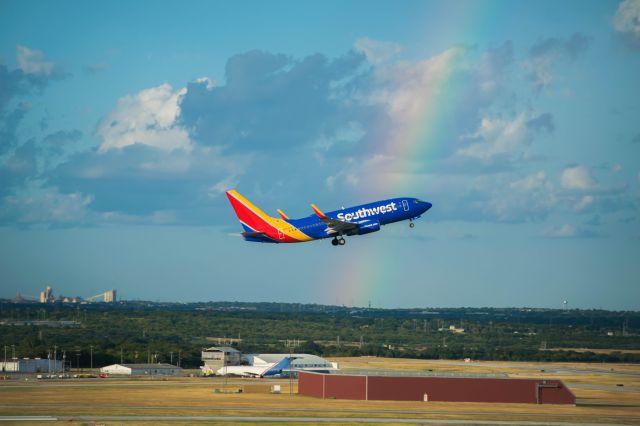 Boeing 737-700 (N7837A) - Departure from 12R with rainbow in background 