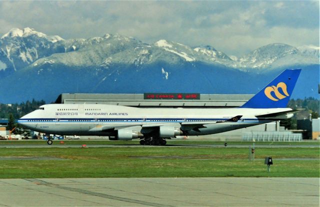 Boeing 747-400 (B-16801) - CYVR - April 1999 in Seattle visiting relatives for a week, we decided to drive up to Vancouver BC Canada and visit the Canadian Vance's and also get some photos at YVR. I was hoping for another Mandarin 747 to arrive but no, this is the only Manadarin 747 I saw, the other one is their 747SPs here. A fresh snow load the night before on the Coast Range of the Canadian Rockies makes a nice backdrop as this 747 departs for Hong Kong.