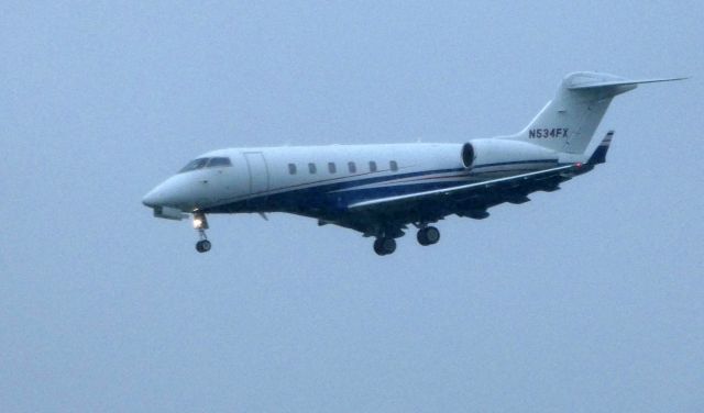 Bombardier Challenger 300 (N534FX) - Shown here a moment until it lands is a Bombardier Challenger 300 in a light Spring shower in 2018.