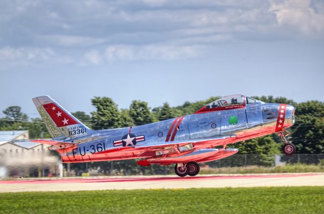 North American F-86 Sabre (N50CJ) - The undersides of this F-86 are not painted red; the polished metal is reflecting the red dot painted on runway 18/36 in Oshkosh, Wisconsin.