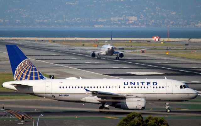 Airbus A319 (N814UA) - KSFO - N814UA positions for Runway 1R as N484UA rolls for V1 nearing the 28LR crosshairs. Mar 07,2015. Click full.