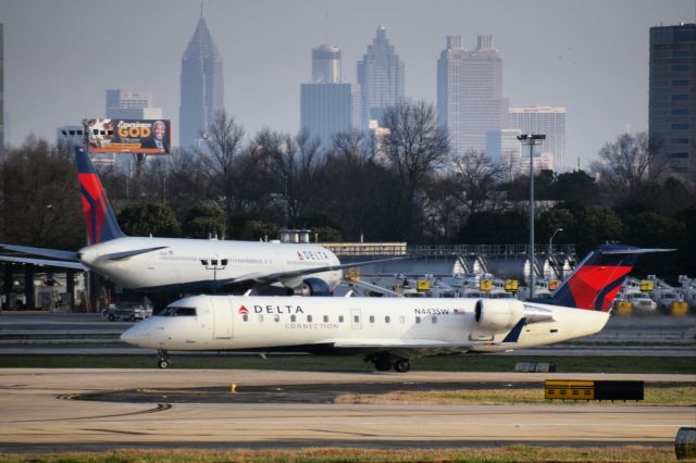 Canadair Regional Jet CRJ-200 (N443SW) - SkyWest Airlines (d.b.a. Delta Connection) CRJ-200ER taxiing at Hartsfield-Jackson with Downtown Atlanta in the background...