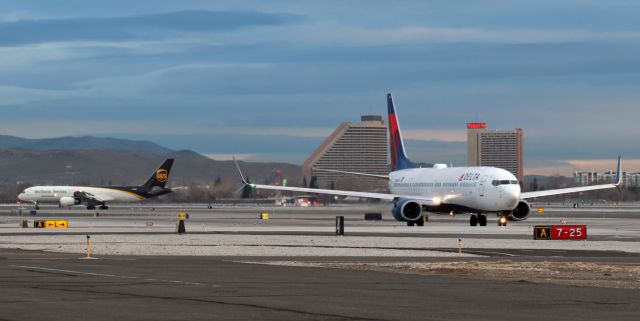 Boeing 737-900 (N805DN) - A pair of Boeings, Delta's N805DN (a B739) and UPS's N444UP (a B752), on the move in the dawn hour at RNO. The Delta jet was taxiing out to Runway 34L for departure to Salt Lake City (KSLC) while the UPS jet was turning off 34L to taxi to the cargo ramp.