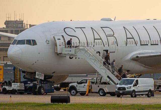 Boeing 777-200 (N76021) - The Cleveland Browns deplaning from a Boeing777 224(ER), with the Star Alliance livery on Pad-3 in, early Sunday morning, 25 Aug 2024, after returning from Seattle-Tacoma Intl (KSEA). The tinted colors are courtesy of an approaching thunderstorm.