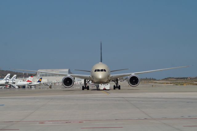Boeing 787-8 (A6-BLL) - Etihads dreamliner asks for push with abandoned ex Olympic Airways technical base in the background