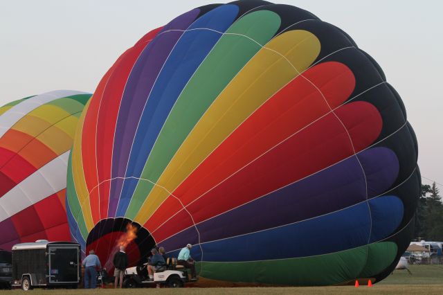 Cessna Skyhawk (N71394) - An Aerostar Raven Balloon begins 'hot' inflation just before an early morning launch from the Ultralite Field at Airventure 2012