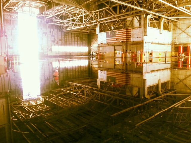 — — - Maintenance hangar following fire system test.  Floor reflecting intricate ceiling structure.