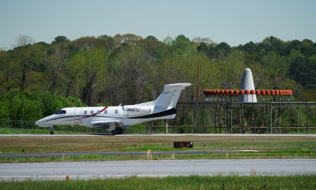 Embraer Phenom 300 (N68TJ) - Just landing at Dekalb Peachtree Airport.  Photographed from the observation stand.  