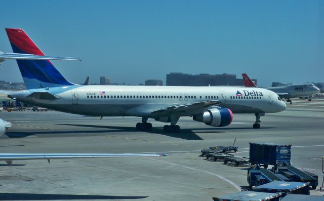 Boeing 757-200 (N752AT) - DL 757-212 N752AT heading to the runway at LAX on Sept 5, 2009. Note the NW 747-400 rotating in the background.