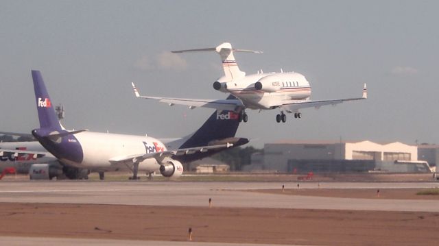 Bombardier Challenger 300 (N35FE) - FedEx corporate CL30 on short final to 18C with big brothers lining up for departure from 18L.