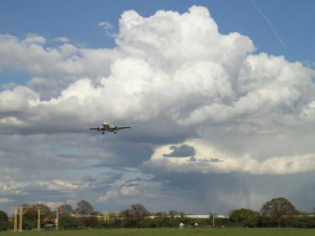 — — - Towering Cumulus Nimbus clouds gather over the approach to London Heathrow.