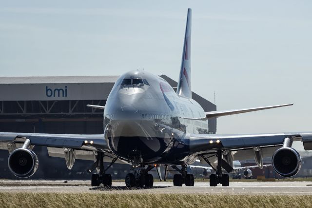 — — - British Airways, B744, taxiing to runway 27R at EGLL. Canon 60D, Canon 70-200mm f4. Since uploading this photo, I have read on another aviation website that Heathrow Airport have placed a very fine mesh across the north and south perimeter fence, making clear photos like this one impossible and also enforced a no closer than 3 metres distance from the fence when taking photos, to discourage this type of photo. Extra tall ladders will be the norm for those still wanting to take these line up shots I imagine.