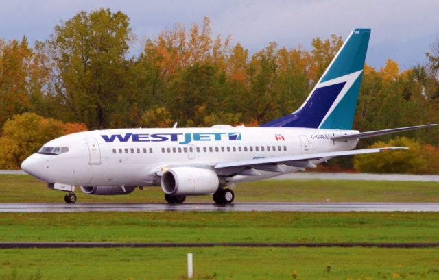 Boeing 737-700 (C-GWJU) - Starting takeoff role down rwy 25 on a wet morning.