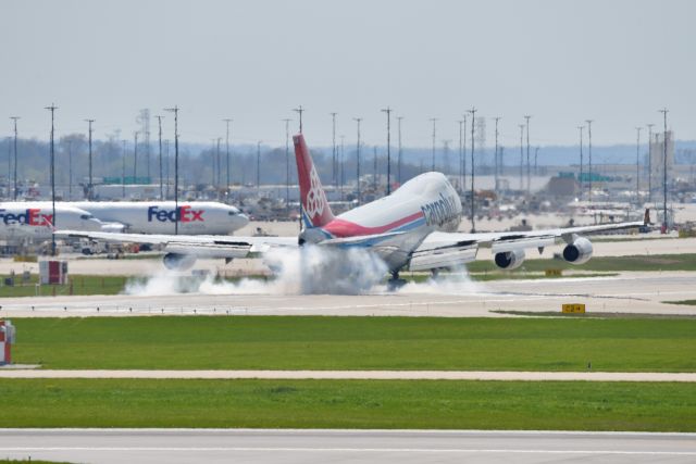 Boeing 747-400 (LX-TCV) - "Torching Down" on 23-L. Apologies for the awful haze filled soft shot, but the smoke on touchdown in this sequence was awesome. You should see the following shots the crazy smoke.