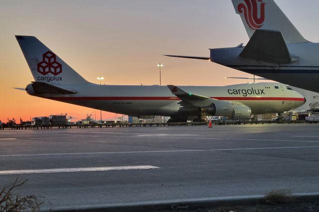 Boeing 747-400 (LX-NCL) - Twilight just past official sunset at North Cargo Ramp on 03-18-23. Love this aircraft. Shot through chain link fence.