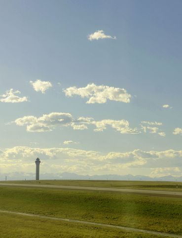 — — - Control tower at KDEN jutting toward the sky.