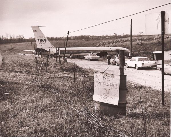 Boeing 707-100 — - Was departing runway 27L when it passed behind a Delta DC-9 which had become stuck in the mud just to the right of the runway. The jetblast from the Delta jet caused a compressor stall in the 707s no. 4 engine. Hearing the bang, and believing that their plane had impacted the Delta DC-9, the TWA crew aborted the takeoff, but the plane overran the runway, climbed over an embankment, and came to rest 420 feet from the runway end. Had they continued the takeoff the outcome would have been better.