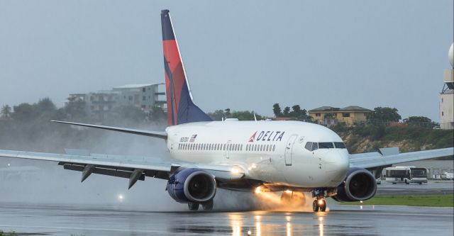 Boeing 737-700 (N307DQ) - Delta airlines landing at TNCM St Maarten on a really wet day.