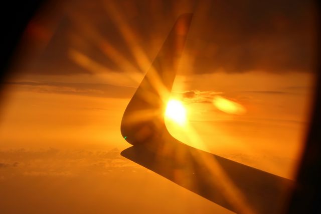 Airbus A321 (B-9957) - Coming into land at Sanya Phoenix Intl. Airport while the sun is setting into the ocean.