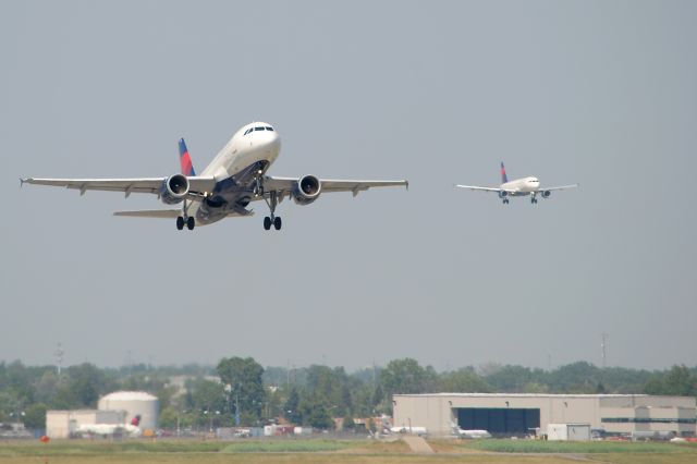 Airbus A319 (N342NB) - Departing KDTW, runway 21R, for KCLT. Another DAL Airbus in the background on short final for runway 21L.