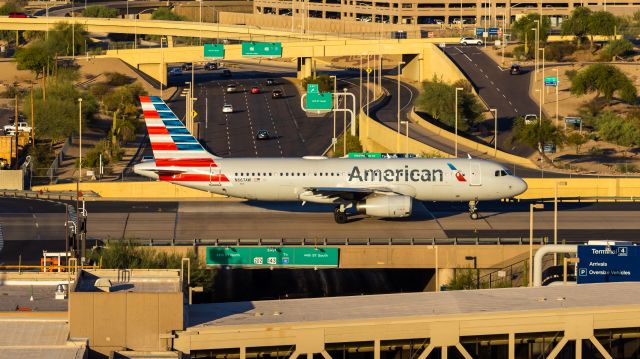 Airbus A320 (N667AW) - American Airlines A320 taxiing over the highway at PHX on 7/7/22. Taken with a Canon 850D and Rokinon 135mm f/2 lens.