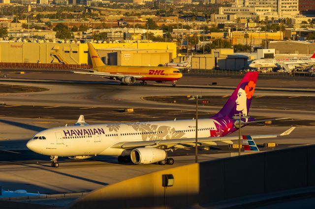 Airbus A330-200 (N391HA) - Hawaiian Airlines A330-200 taxiing while an ABX 767-300 lands in the background at PHX on 11/9/22. Taken with a Canon R7 and Tamron 70-200 G2 lens.