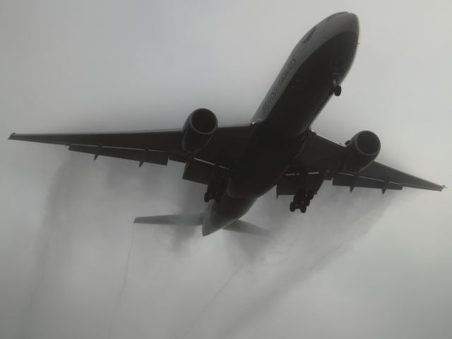 Boeing 777-200 — - Condensation clouds trail behind the wing of this B777-236ER as it approaches LHR.