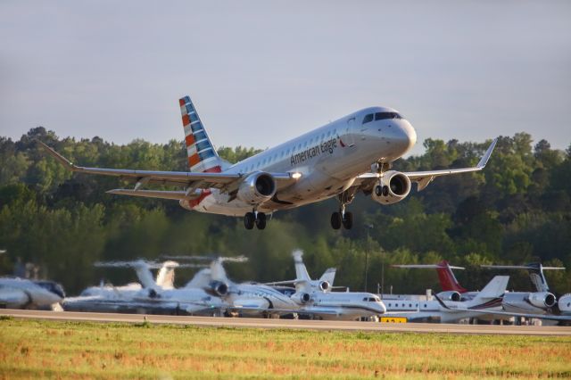 Embraer 170/175 (N216NN) - N216NN is a 2015 Embraer ERJ 170-200 LR jet seen here departing Augusta Georgia's regional airport shortly after the conclusion of the 2023 Masters golf tournament. In the background you can see a small sampling of the extensive billionaire's row jet parking. I also liked this photo for how the grassy field was lighting up with a nice golden color and some wild flowers were showing a reddish glow as the sun was getting low. I shot this with a Canon 5Dsr and a Canon 500mm lens with a 1.4x extender on it making the lens' focal length 700mm. Camera settings were 1/8000 shutter, F5.6, ISO 2500. Please check out my other aviation photography. Votes and positive comments are always appreciated. Questions about this photo can be sent to Info@FlewShots.com