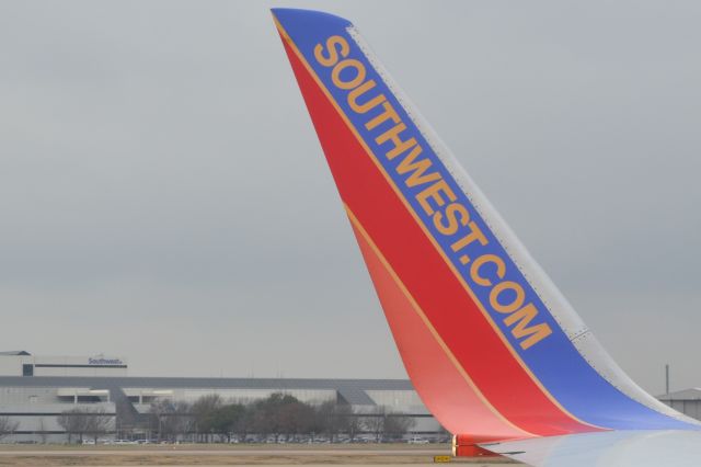 Boeing 737-700 (N7713A) - Taxiing with SWA HQ in the background at KDAL - 2/8/21