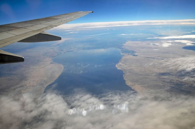 — — - The salton sea from the seat of a Sun country aircraft leaving San Diego CA back to Minneapolis MN to the snow. 