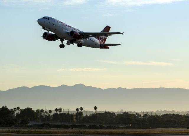 Airbus A319 (N528VA) - The "Fog Cutter" (see name below captains window) makes sunrise takeoff into the Los Angeles smog from runway 24R LAX. Los Angeles, California USA.