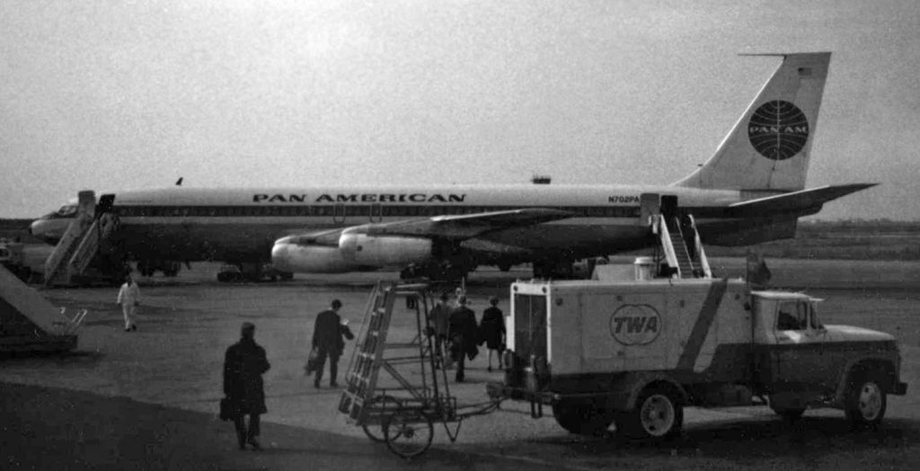 Boeing 707-100 (N702PA) - Pan Americans "Clipper Hotspur" (N702PA, a Boeing 707) is seen in this scan of a 47-year-old Polaroid snapshot as passengers are boarding at Fiumicino-Leonardo da Vinci International Airport (Rome, Italy) for a flight to Ankara, Turkey.br /I did the very best editing that I could with this photo.  It was taken on a Polaroid camera, and this print is almost a half-century old.  Anyone who knows about Polaroid pictures knows they printed instantly.  To still have any type of image at all after 47 years of exposure to light is rather amazing.  This is a color picture, but it was so badly faded and color-distorted that I finally gave up on trying to salvage it as a color photo and I simply converted it to black & white.br /I snapped this picture in March or April of 1969 at Rome (Italy) Fiumicino International Airport.  This was a stop on my PAA flight from New York to Ankara (Turkey) while I was enroute to my first duty assignment in Trabzon, Turkey.  