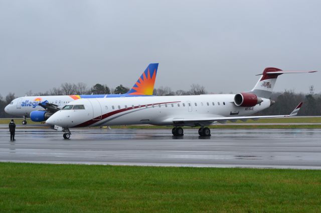 Canadair Regional Jet CRJ-700 (N519JG) - JOE GIBBS RACING INC on a rainy day with AAY1253 (N233NV) in the background at KJQF - 3/1/18