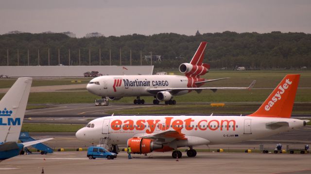 Airbus A319 (G-EJAR) - easyJet A319-111 (G-EJAR) in AMS in foreground, Martinair Cargo MD11 (PH-MCW) in background. (Photo May 2007)