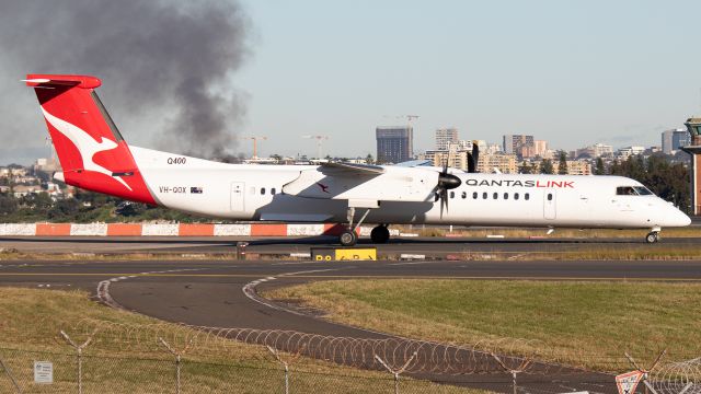 de Havilland Dash 8-400 (VH-QOX) - QLK Q400 taxiing past sheps mound with a factory fire in the background. 