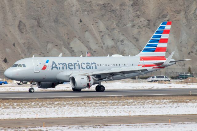 Airbus A319 (N9022G) - American 2189 from Dallas-Fort Worth, TX with the American flag blending in with it in the background. 6 Feb 2021.